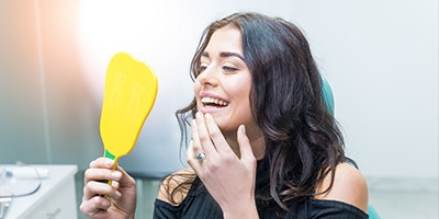 Woman looking at smile in mirror