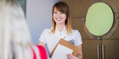 Smiling dental team member greating dentistry patient