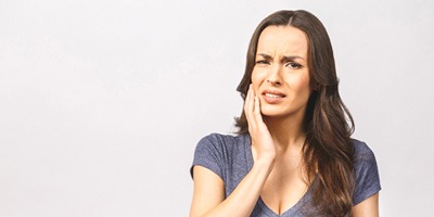 Woman with mouth pain, worried about a possible failed dental implant