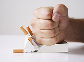 Fist smashing cigarettes, determined to break bad habit