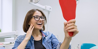Young woman admires her new dental implants in Carmichael