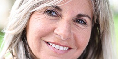 Woman smiles after getting dental implants in Carmichael