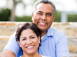 Smiling couple with dental implants in Carmichael