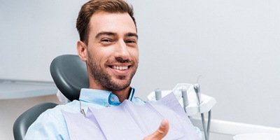 Male dental patient giving thumbs up