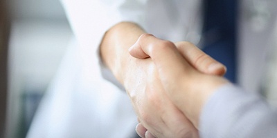 Dentist and patient shaking hands after procedure