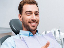 Male dental patient giving thumbs up
