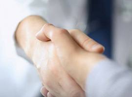 Dentist and patient shaking hands after procedure