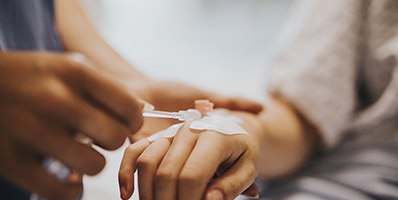 Patient getting IV inserted into hand before oral surgery