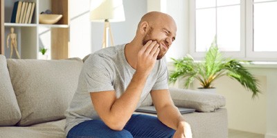 man holding jaw in pain 