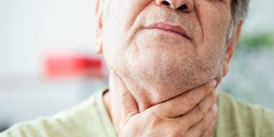 older man feeling pain in throat  