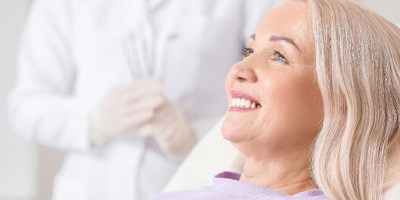 woman smiling while sitting in dental chair   