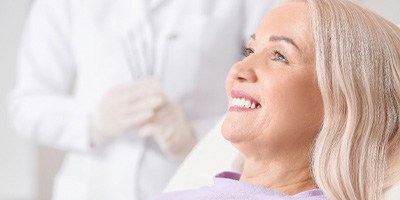 woman smiling while sitting in dental chair