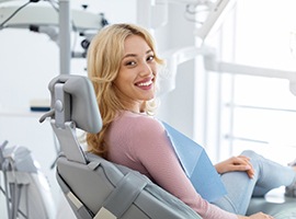 Smiling dental patient looking over her shoulder