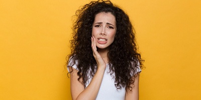Woman with toothache, in need of emergency dentistry