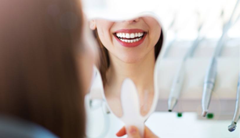 Woman looking at smile in mirror