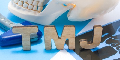 Model of skull with letters “TMJ” in front