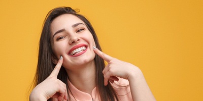 Young woman smiling after undergoing successful TMJ therapy