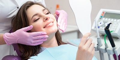 woman smiling in dental mirror 