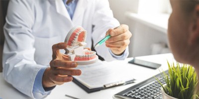 dentist talking to patient about cost of wisdom tooth extraction