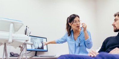 dentist discussing factors that influence cost of wisdom tooth extraction
