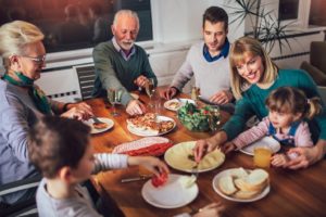 Happy family eating dinner together, grateful for dental implants