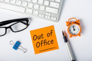 “Out of office” note on desk for person recovering from dental implant surgery