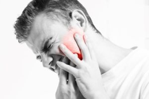 Black and white photo of man with dental pain