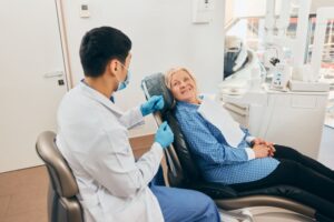 Patient and oral surgeon talking during dental implant consultation 