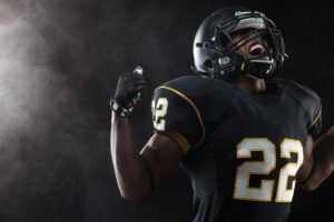 Man in football helmet and jersey celebrating victory